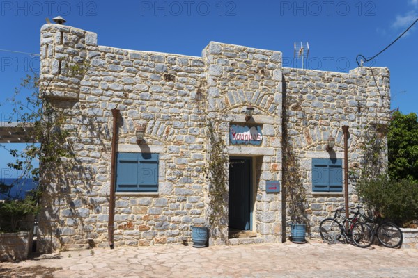 A stone house with a green door and a bicycle in front of it, Limeni, Areopoli, Laconia, Peloponnese, Greece, Europe