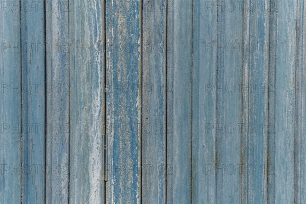 Garage door boards stained blue with worn paint. Brittany France
