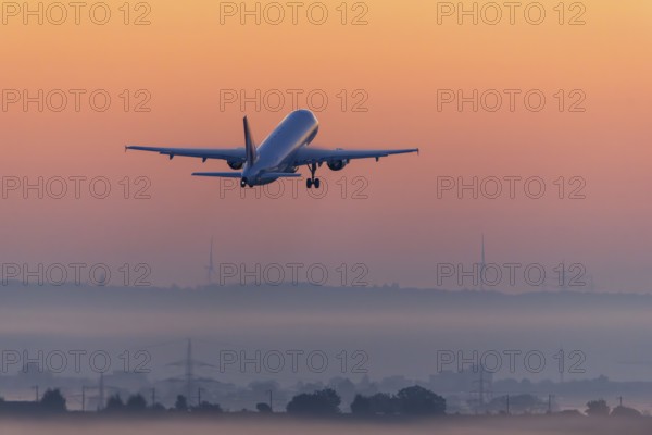 Passenger aircraft after take-off, in front of sunrise, fog, Baden-Württemberg, Germany, Europe