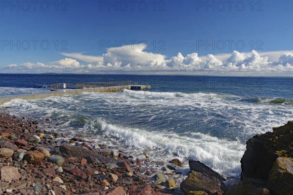 Coastal landscape with stormy waves on a rocky shore under a cloudy blue sky, Tönsberg, Oslofjord, Norway, Europe