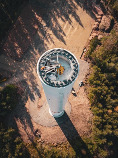 A tall wind turbine under construction, surrounded by forest and autumn atmosphere seen from above, wind turbine construction, Calmbach, Black Forest, Germany, Europe