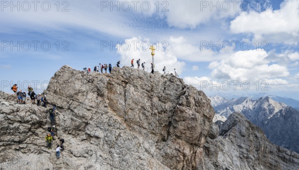 Tourists queue up for the summit of the Zugspitze, summit with golden summit cross, overtourism, Wetterstein range, Bavaria, Germany, Europe