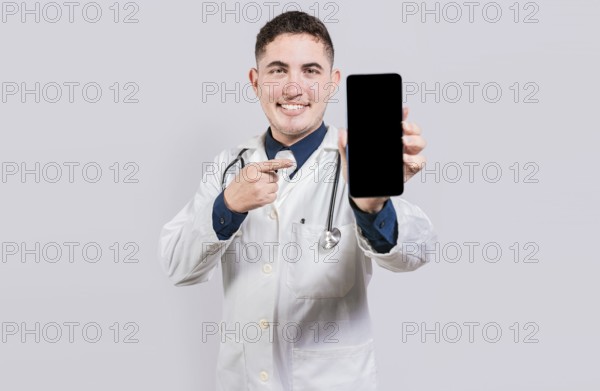 Smiling doctor showing an app on cell phone screen. Happy young doctor showing cell phone screen isolated
