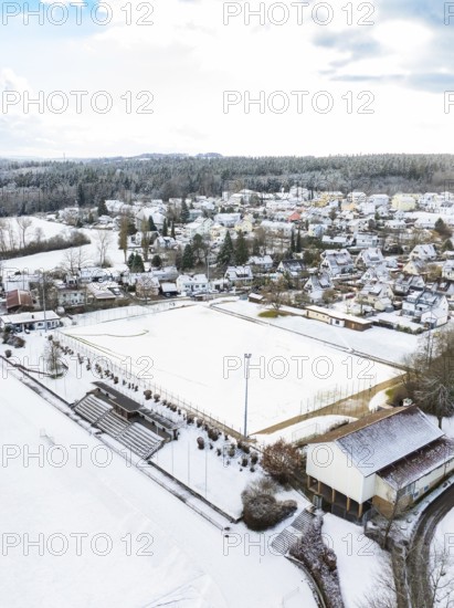 Residential area and sports field under a blanket of snow surrounded by wintry trees and buildings, Calw- Wimberg, district of Calw, Black Forest, Germany, Europe