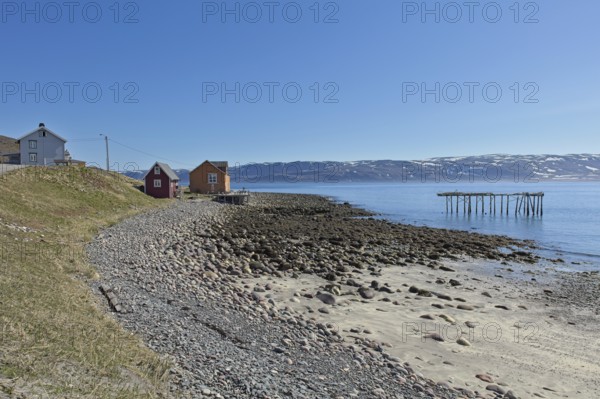 Buildings at seashore at Veidnes on a clear summer day, Kongsfjord, Norway, Europe