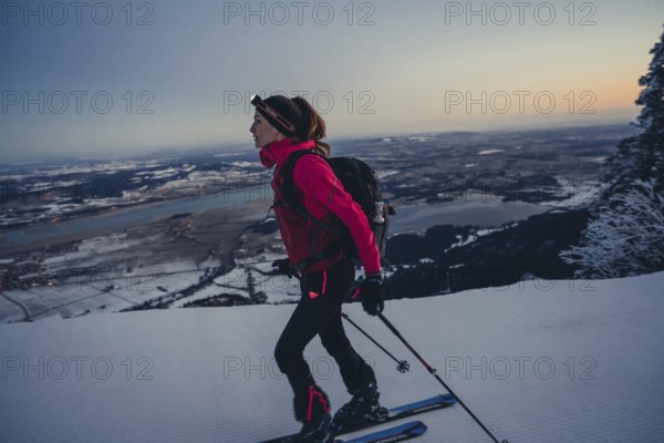 A woman's ski tour at sunrise on the Tegelberg in the Allgäu in the Ammergebirge, Bavaria, Germany, Europe