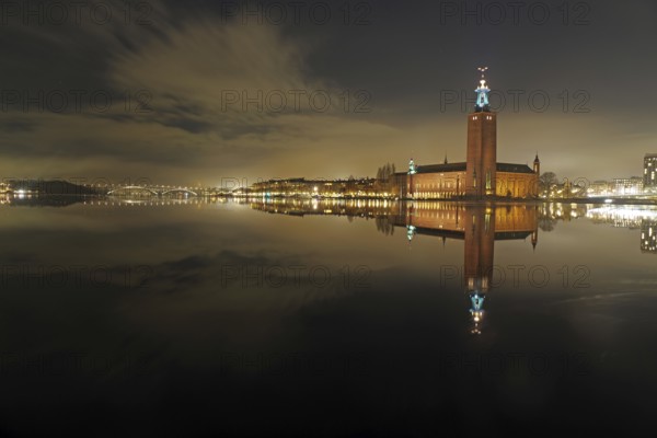 Night city view with illuminated tower and bridges in the background, winter, ice, capital, city hall, Stadshus, Nobel Prize, Stockholm, Sweden, Europe