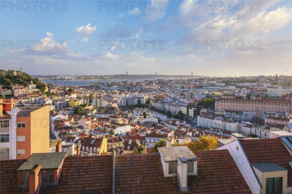 View of Lisbon famous view from Miradouro da Senhora do Monte tourist viewpoint of Alfama and Mauraria old city districts, 25th of April Bridge on sunset. Lisbon, Portugal, Europe