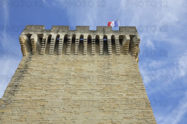 Porte d'Orange with battlements, city gate with French national flag, defence defence tower, view from below, cut-out, Carpentras, Vaucluse, Provence, France, Europe