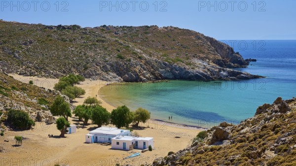 Secluded bay with clear water and golden sand, houses and trees, embedded in a rocky landscape under a bright sky, tamarisk trees, taverna, Psili Ammos Srand, Patmos, Dodecanese, Greek Islands, Greece, Europe