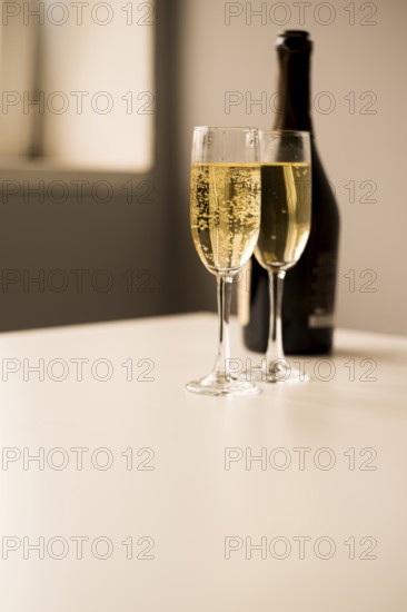 Champagne glasses with bottle white table