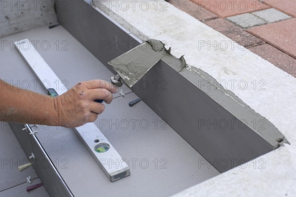 Tiler hands working on a new house entrance, local and professional handyman applying tiles to the steps