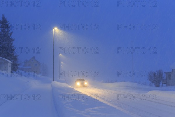 Winter road in driving snow, twilight, Finnsnes, Troms og Finnmark, Norway, Europe