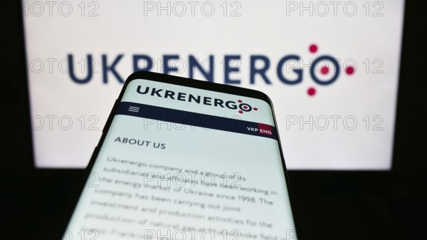 Stuttgart, Germany, 10-27-2023: Mobile phone with webpage of Ukrainian national power company Ukrenergo in front of business logo. Focus on top-left of phone display, Europe