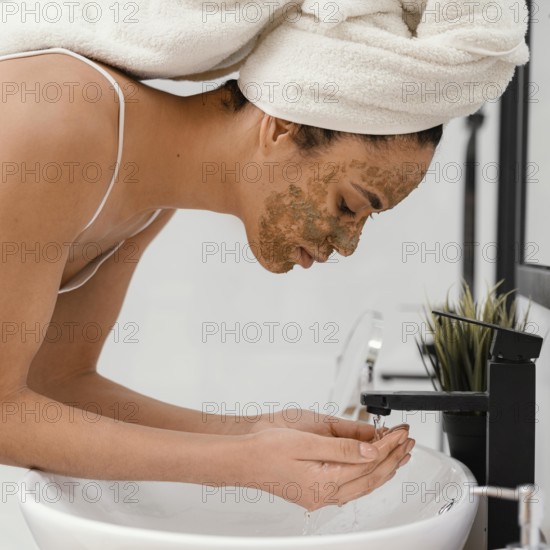 Woman washing her face after having homemade mask