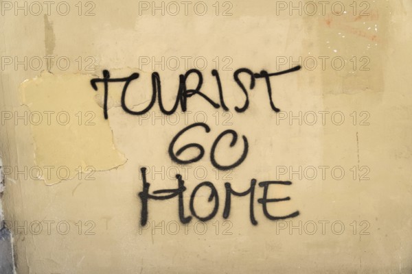 Tourist go home lettering on a wall in Barcelona, Spain, Europe