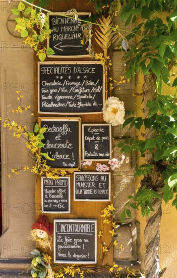Riquewihr, France - 30 May, 2022: close-up view of many handwritten signs in French language advertising Alsatian food and specialities in a small shop