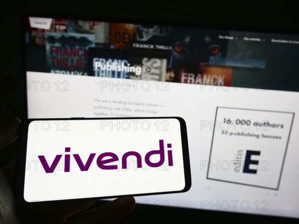 Stuttgart, Germany, 04-04-2023: Person holding cellphone with logo of French mass media company Vivendi SE on screen in front of business webpage. Focus on phone display, Europe