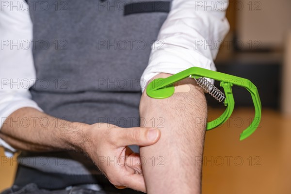 Close-up of an unrecognizable male volunteer pressing arm to prevent a leak after donating blood
