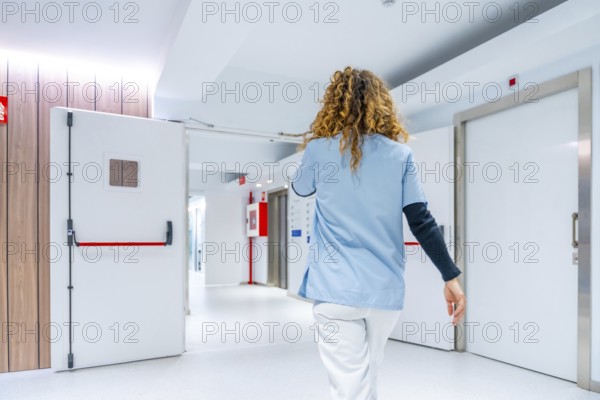 Rear view of a nurse in a rush along the emergency area of an hospital