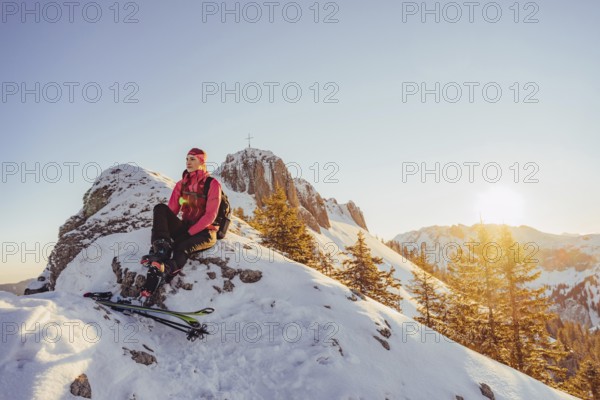 A woman's ski tour at sunrise on the Tegelberg in the Allgäu in the Ammergebirge, Bavaria, Germany, Europe