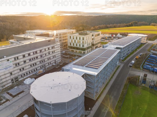 Large industrial complex with solar panels and surrounding nature at sunset, new Calw health campus, Calw district, Black Forest, Germany, Europe