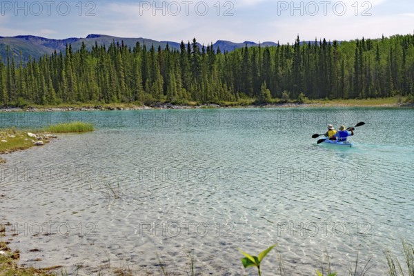 Transparent clear lake and two paddlers in a boat, Boya Provincial Park, Stewart Cessiar Highway, HW 37, British Columbia, Canada, North America