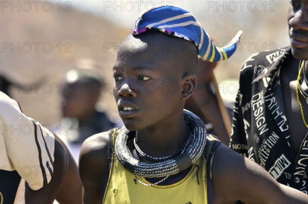 Young Himba man wearing a traditional headdress, cap in the form of a cattle horn, Omohanja, Kaokoland, Kunene, Namibia, Africa
