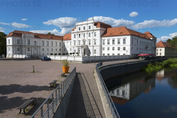 A baroque castle next to a bridge over a river, surrounded by flowering plants, Oranienburg Castle, museum, Oranienburg, Havel River, Oberhavel district, Brandenburg, Germany, Europe