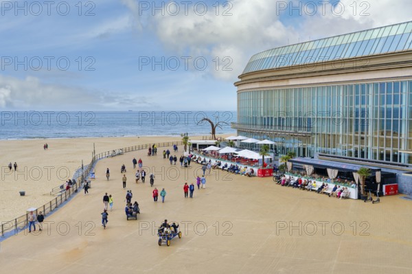 People walking and resting on Ostende promenade near the Kuursal casino, Ostende, West Flanders, Belgium, Europe