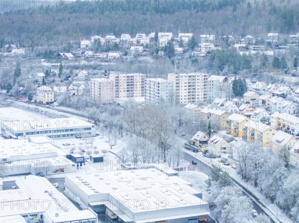 Snowy urban landscape with high-rise buildings and neighbouring forest area, Nagold, Black Forest, Germany, Europe