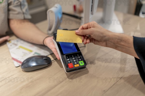 Close-up of a client paying using contactless credit card in a pharmacy