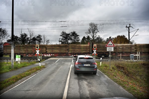 Passing goods train at a level crossing with barriers, Fürth, Middle Franconia, Bavaria, Germany, Europe