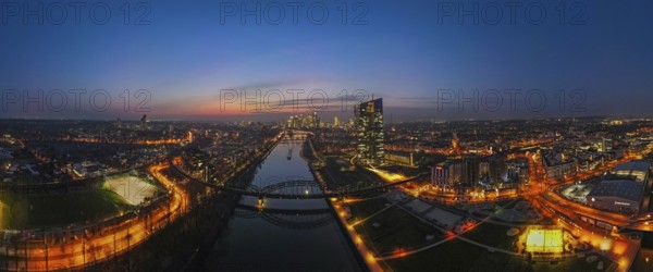 The lights of the European Central Bank (ECB) and the Frankfurt banking skyline glow in the evening. (Aerial view with a drone), Osthafen, Frankfurt am Main, Hesse, Germany, Europe