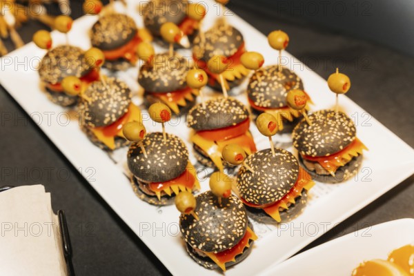 Halloween food and candy in the shape of pumpkins at a party, little ghost burger