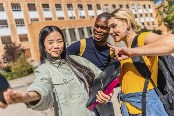 Multi-ethnic university students gesturing success with fingers while taking selfie at the campus