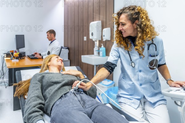 Nurse performing an ultrasound to the belly of a woman lying on stretcher in the hospital