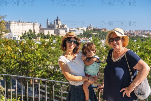 A family with child visiting the Cathedral of Santa Maria la Real de la Almudena and Royal Palace in Madrid capital of Spain