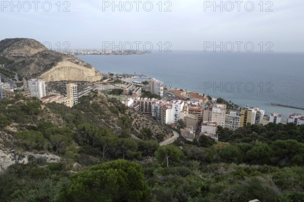 A view of buildings and apartments along the coastline near Alicante on a hazy day. Alicante, Spain, Europe