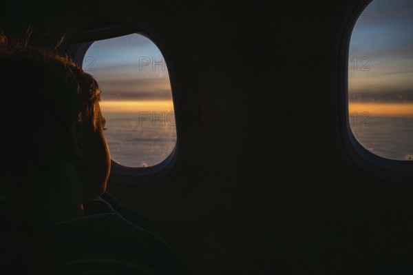 Boy looking throw the window in the flying airplane