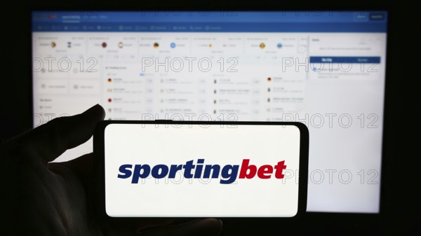 Stuttgart, Germany, 06-06-2024: Person holding cellphone with logo of British sports betting company Sportingbet plc in front of business webpage. Focus on phone display, Europe