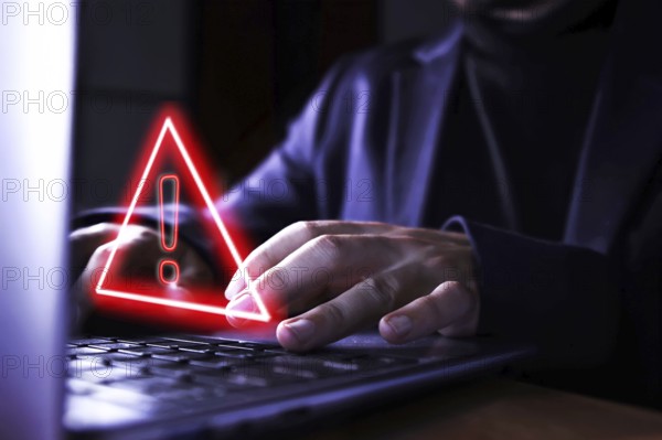 Hands of a businessman using the computer on fraudulent pages. Caution symbol of danger of hackers and malicious viruses when surfing the Internet. Concept of control and technological security.