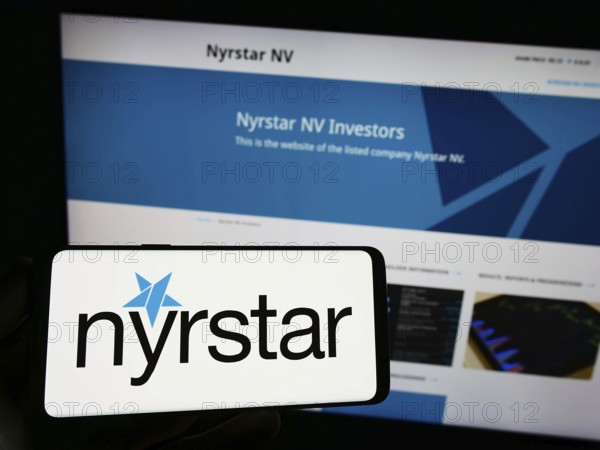 Stuttgart, Germany, 07-28-2023: Person holding smartphone with logo of Dutch mining company Nyrstar on screen in front of website. Focus on phone display, Europe