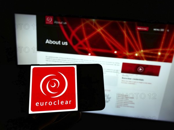 Stuttgart, Germany, 01-06-2022: Person holding mobile phone with logo of Belgian financial company Euroclear Group on screen in front of business web page. Focus on phone display, Europe