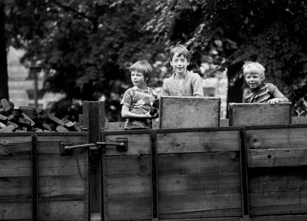 14/03/1982 GDR East Berlin district of Prenzlauer Berg. Three boys playing on a parked coal wagon with briquettes. Berlin