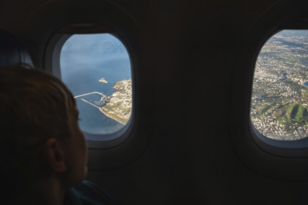 Boy looking throw the window in the flying airplane