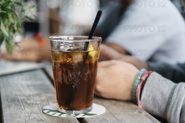 Refreshing glass of cola on wooden table in a bar