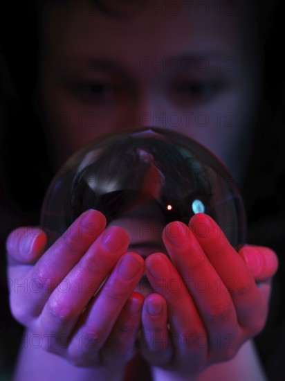 Woman looking into a crystal ball in her hands