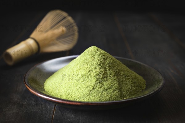Japanese matcha green tea in a cup and tea powder close-up