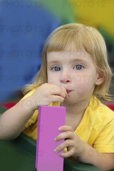 Beautiful blond girl drinking pink juice with strobe